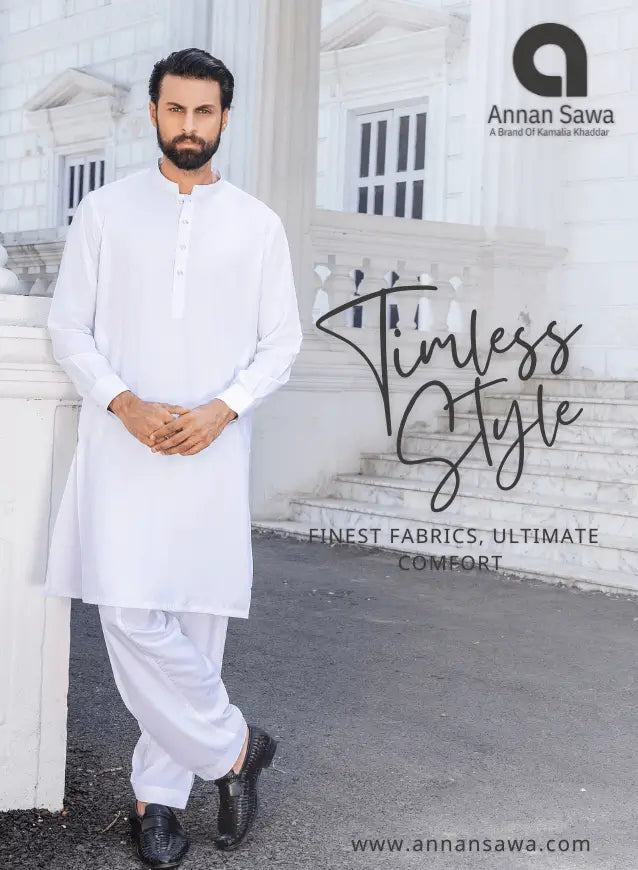 Man in a white kurta standing in front of a classical building with 'Annan Sawa' branding.